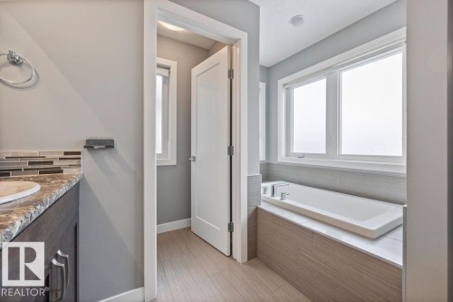 Full bath featuring a bath, vanity, and decorative backsplash - 7515 178 Avenue, Edmonton, AB - Indoor Photo Showing Bathroom