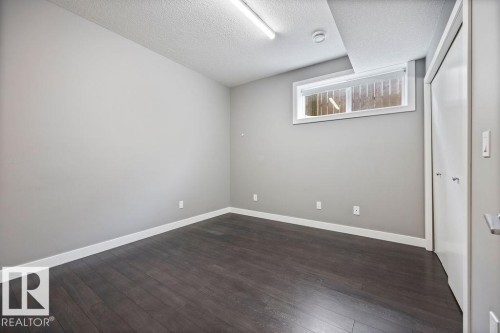 Empty room with dark wood-style floors and a textured ceiling - 7515 178 Avenue, Edmonton, AB - Indoor Photo Showing Other Room
