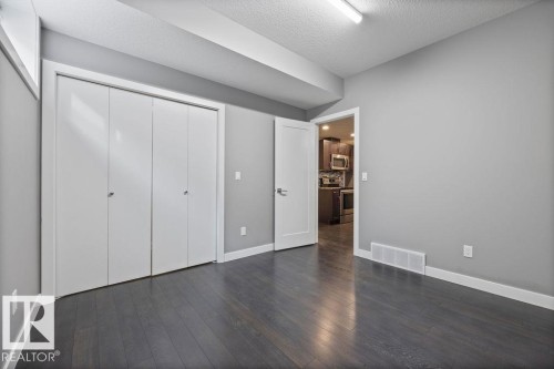 Unfurnished bedroom featuring dark wood-style floors, a closet, and a textured ceiling - 7515 178 Avenue, Edmonton, AB - Indoor Photo Showing Other Room