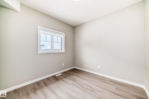 Unfurnished room with baseboards and light wood-style floors - 3323 Roy Brown Way, Edmonton, AB - Indoor Photo Showing Other Room