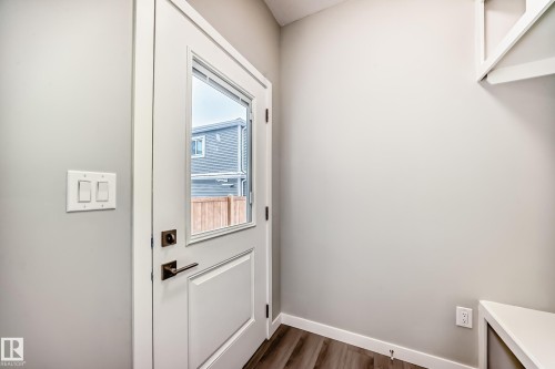Doorway to outside with baseboards and wood finished floors - 3323 Roy Brown Way, Edmonton, AB - Indoor Photo Showing Other Room