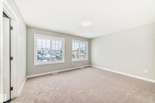 Unfurnished room featuring baseboards and light colored carpet - 3323 Roy Brown Way, Edmonton, AB - Indoor Photo Showing Other Room