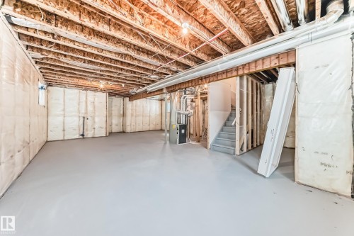 Unfinished basement featuring stairway and heating unit - 3323 Roy Brown Way, Edmonton, AB - Indoor Photo Showing Basement