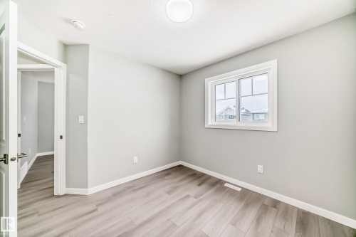 Empty room with light wood-style flooring and baseboards - 3323 Roy Brown Way, Edmonton, AB - Indoor Photo Showing Other Room