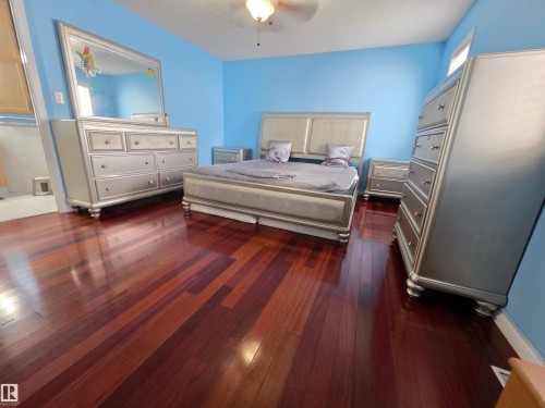 Bedroom with dark wood-type flooring and ceiling fan - 6731 162 Ave, Edmonton, AB - Indoor Photo Showing Bedroom