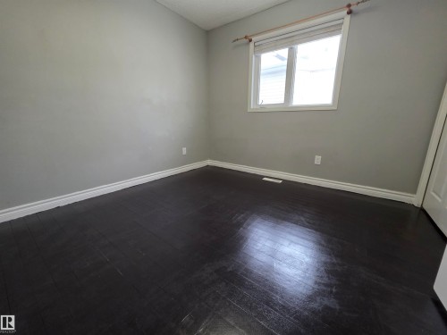 Unfurnished room featuring baseboards and dark wood-style flooring - 6731 162 Ave, Edmonton, AB - Indoor Photo Showing Other Room