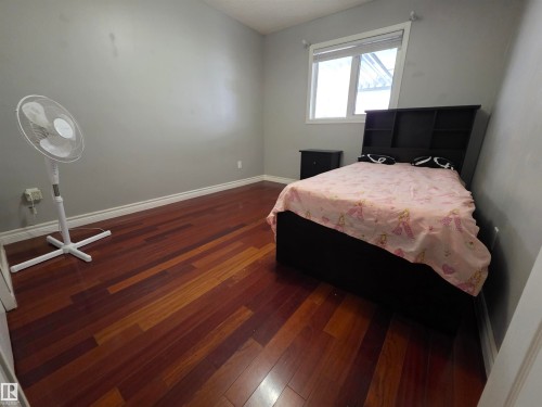 Bedroom with dark wood finished floors and baseboards - 6731 162 Ave, Edmonton, AB - Indoor Photo Showing Bedroom