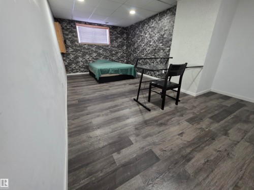 Bedroom with a paneled ceiling, an accent wall, recessed lighting, and dark wood-style floors - 6731 162 Ave, Edmonton, AB - Indoor