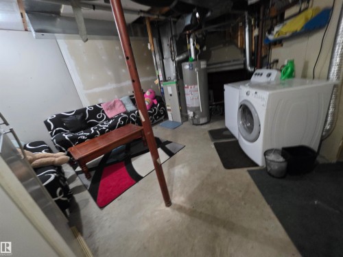 Unfinished below grade area featuring water heater and independent washer and dryer - 6731 162 Ave, Edmonton, AB - Indoor Photo Showing Laundry Room