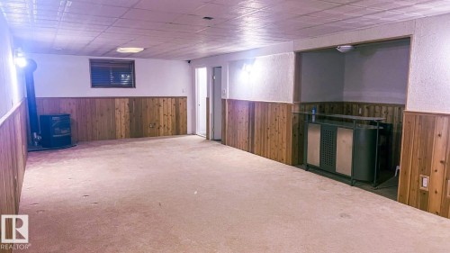 Finished basement featuring wooden walls, a wainscoted wall, carpet floors, and a textured wall - 6731 162 Ave, Edmonton, AB - Indoor