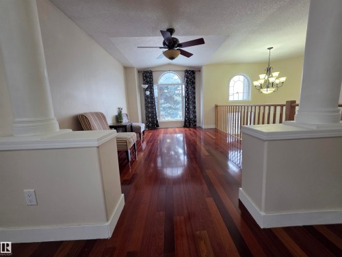 Hall featuring ornate columns, a chandelier, and dark wood-type flooring - 6731 162 Ave, Edmonton, AB - Indoor Photo Showing Other Room