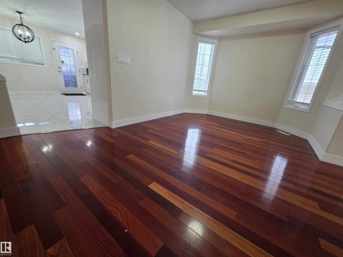 Unfurnished room featuring dark wood finished floors and hanging lights - 6731 162 Ave, Edmonton, AB - Indoor Photo Showing Other Room