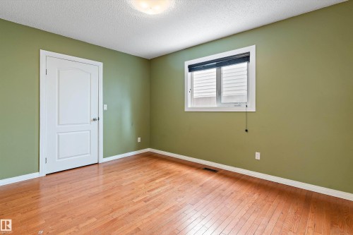 Spare room featuring a textured ceiling and light wood finished floors - 115 Walker Road, Edmonton, AB - Indoor Photo Showing Other Room