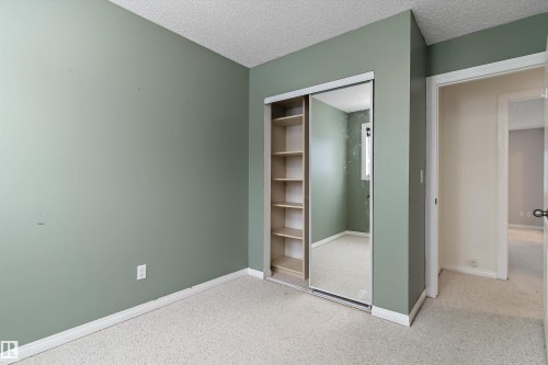 Unfurnished bedroom featuring a textured ceiling and a closet - 115 Walker Road, Edmonton, AB - Indoor Photo Showing Other Room