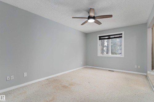 Empty room featuring a textured ceiling, ceiling fan, and carpet - 115 Walker Road, Edmonton, AB - Indoor Photo Showing Other Room