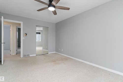 Unfurnished bedroom featuring a closet, a ceiling fan, and a textured ceiling - 115 Walker Road, Edmonton, AB - Indoor Photo Showing Other Room