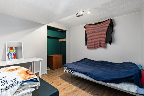 Bedroom featuring light wood finished floors and a textured ceiling - 115 Walker Road, Edmonton, AB - Indoor Photo Showing Bedroom