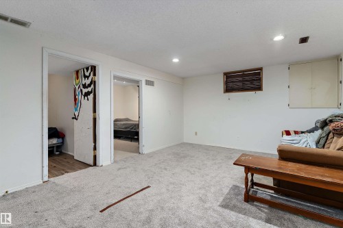 Living area with carpet flooring, recessed lighting, and a textured ceiling - 115 Walker Road, Edmonton, AB - Indoor Photo Showing Other Room
