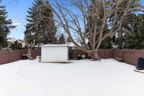 Yard covered in snow featuring a fenced backyard and a storage unit - 115 Walker Road, Edmonton, AB - Outdoor