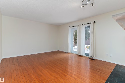 Unfurnished room featuring hardwood / wood-style flooring and a textured ceiling - 115 Walker Road, Edmonton, AB - Indoor Photo Showing Other Room