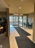 Community lobby featuring a textured wall and recessed lighting - 310 2430 Guardian Road, Edmonton, AB  - Indoor Photo Showing Other Room 