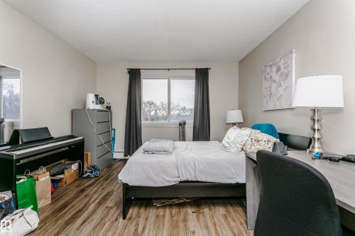 Bedroom featuring wood finished floors and a textured ceiling - 407 8149 111 St S, Edmonton, AB - Indoor Photo Showing Bedroom