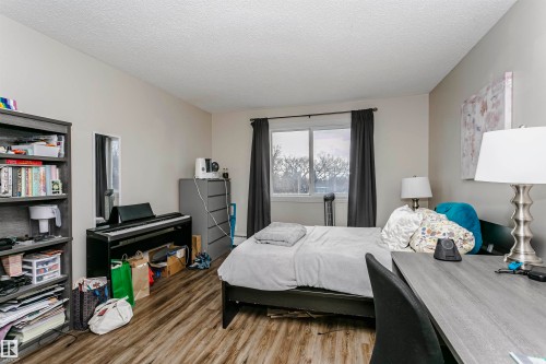 Bedroom featuring wood finished floors and a textured ceiling - 407 8149 111 St S, Edmonton, AB - Indoor Photo Showing Bedroom