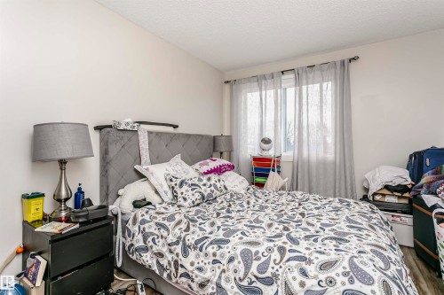 Bedroom with a textured ceiling and wood finished floors - 407 8149 111 St S, Edmonton, AB - Indoor Photo Showing Bedroom