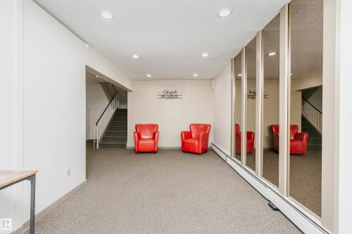 Living area featuring a baseboard heating unit, a textured ceiling, and recessed lighting - 407 8149 111 St S, Edmonton, AB - Indoor Photo Showing Other Room
