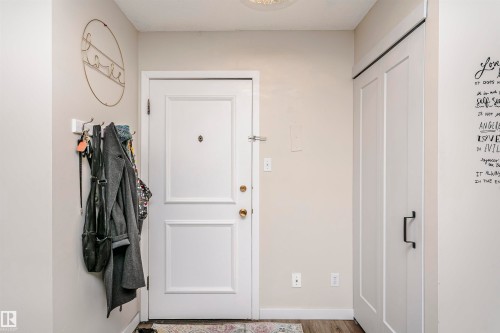Doorway with baseboards and wood finished floors - 407 8149 111 St S, Edmonton, AB - Indoor Photo Showing Other Room