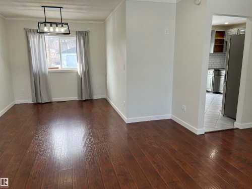 Unfurnished dining area with dark wood-type flooring and crown molding - 10832 163 Street, Edmonton, AB - Indoor Photo Showing Other Room