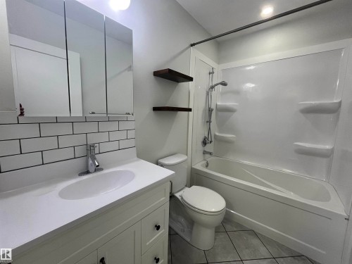 Full bathroom featuring vanity, tasteful backsplash, bathing tub / shower combination, and light tile patterned floors - 10832 163 Street, Edmonton, AB - Indoor Photo Showing Bathroom