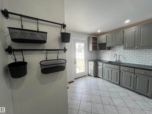 Kitchen featuring gray cabinetry, dark countertops, open shelves, backsplash, and recessed lighting - 10832 163 Street, Edmonton, AB - Indoor Photo Showing Kitchen