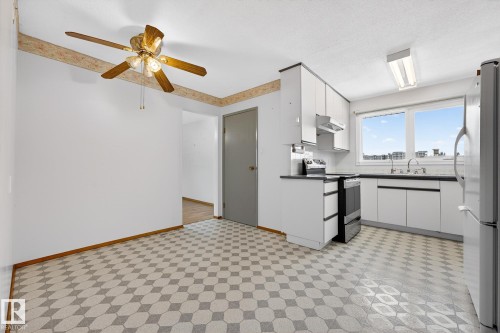 Kitchen featuring dark countertops, stainless steel appliances, light floors, white cabinetry, and a ceiling fan - 21 Marchand Place, St. Albert, AB - Indoor Photo Showing Kitchen