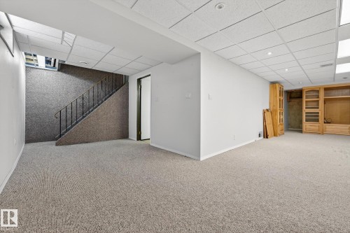 Finished basement with light colored carpet and a drop ceiling - 21 Marchand Place, St. Albert, AB - Indoor