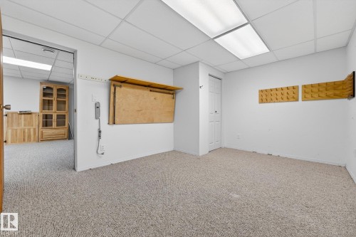 Carpeted empty room featuring a paneled ceiling and baseboards - 21 Marchand Place, St. Albert, AB - Indoor
