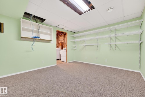 Finished below grade area with light carpet, a paneled ceiling, and washing machine and dryer - 21 Marchand Place, St. Albert, AB - Indoor Photo Showing Other Room