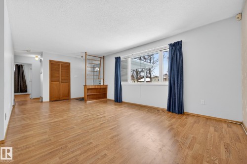 Unfurnished living room featuring light wood-style flooring and a textured ceiling - 21 Marchand Place, St. Albert, AB - Indoor
