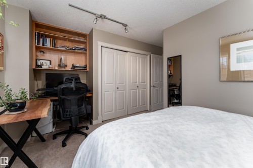 Bedroom featuring a desk, light carpet, a closet, track lighting, and a textured ceiling - 10906 72 Avenue, Edmonton, AB - Indoor Photo Showing Bedroom