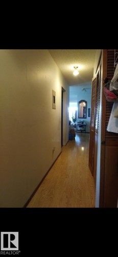 The property features a hallway with light-toned flooring, a light-colored wall, and a ceiling light fixture - 401 10743 107 Street Nw, Edmonton, AB - Indoor Photo Showing Other Room