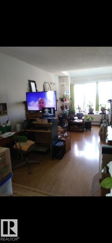 The living area features light-colored flooring and large windows, providing abundant natural light - 401 10743 107 Street Nw, Edmonton, AB - Indoor