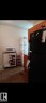 The kitchen features a black refrigerator, wood cabinetry, and a white display cabinet - 401 10743 107 Street Nw, Edmonton, AB  - Indoor 