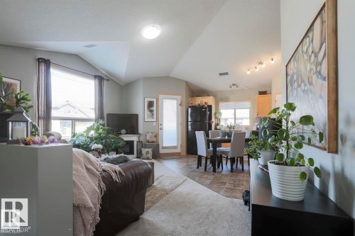 Living area with lofted ceiling and stone finish flooring - 86 604 62 Street, Edmonton, AB - Indoor