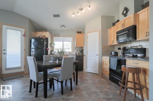 Dining space with stone finish floors and lofted ceiling - 86 604 62 Street, Edmonton, AB - Indoor
