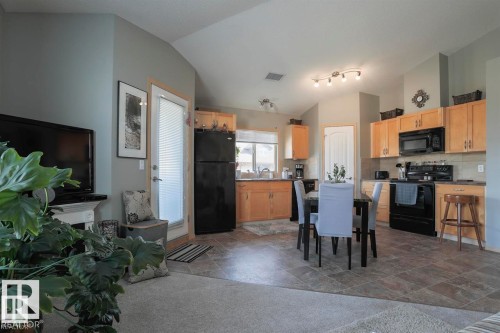 Dining area featuring vaulted ceiling and dark stone finish flooring - 86 604 62 Street, Edmonton, AB - Indoor