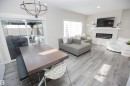 Living room with suspended lighting, a glass covered fireplace, and wood finished floors - 15 Springbrook Wynd, Spruce Grove, AB  - Indoor Photo Showing Living Room With Fireplace 