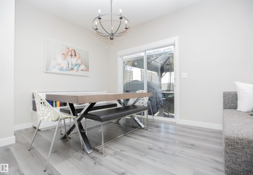 Dining room with hanging lights and light wood-style floors - 15 Springbrook Wynd, Spruce Grove, AB - Indoor Photo Showing Dining Room