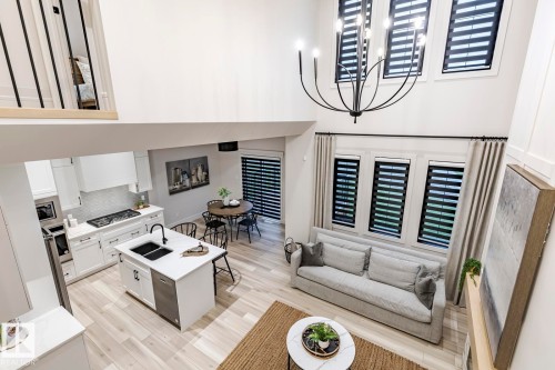Living room with light wood-style flooring, a high ceiling, and suspended lighting - 6275 180 Avenue, Edmonton, AB - Indoor Photo Showing Other Room