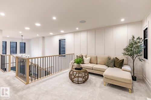 Carpeted living area with a decorative wall and a chandelier - 6275 180 Avenue, Edmonton, AB - Indoor