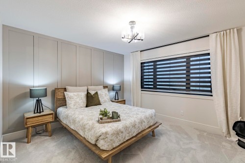 Bedroom featuring a decorative wall, light carpet, and a textured ceiling - 6275 180 Avenue, Edmonton, AB - Indoor Photo Showing Bedroom